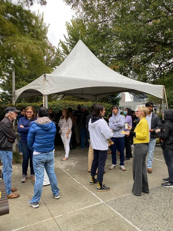 group of students, faculty, and alumni under the tailgate tent