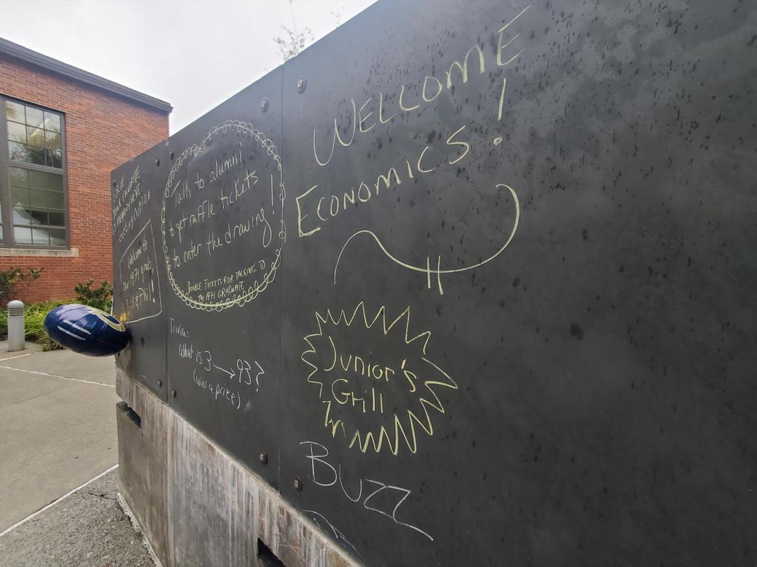Outdoor chalkboard with homecoming and econ messaging written on it