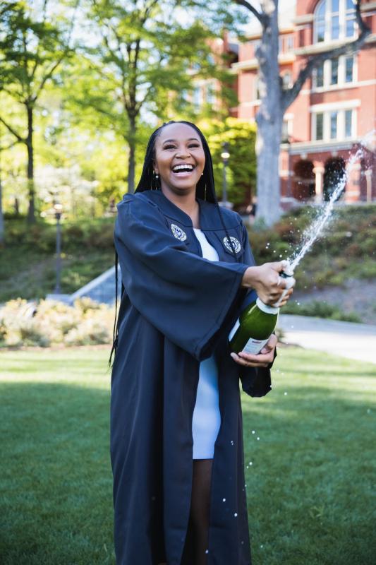 Whitney Miller pops a bottle of champagne to celebrate graduation