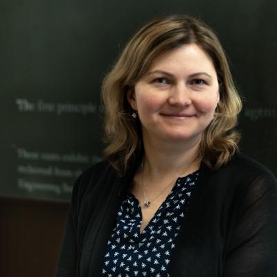 headshot of associate professor Olga Shemyakina in front of a black chalkboard