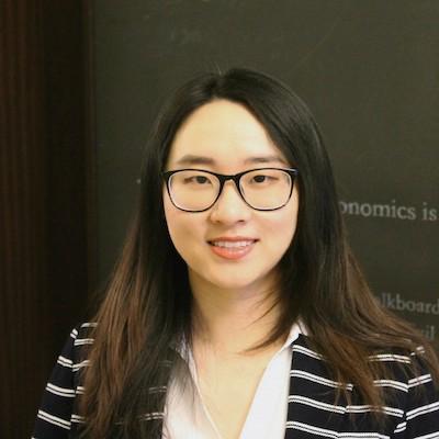 Headshot of postdoctoral fellow Jie Chen in front of a black chalkboard background